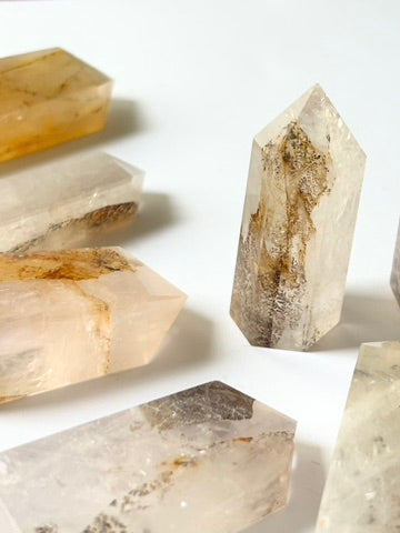 Golden Healer Dendritic Quartz tower displayed on a crystal altar with herbs and candles, radiating healing energy and ancestral connection.