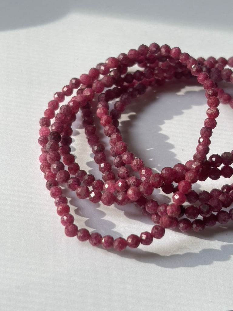 Close-up of crystal healing bracelets showing detailed gemstone faceted ruby