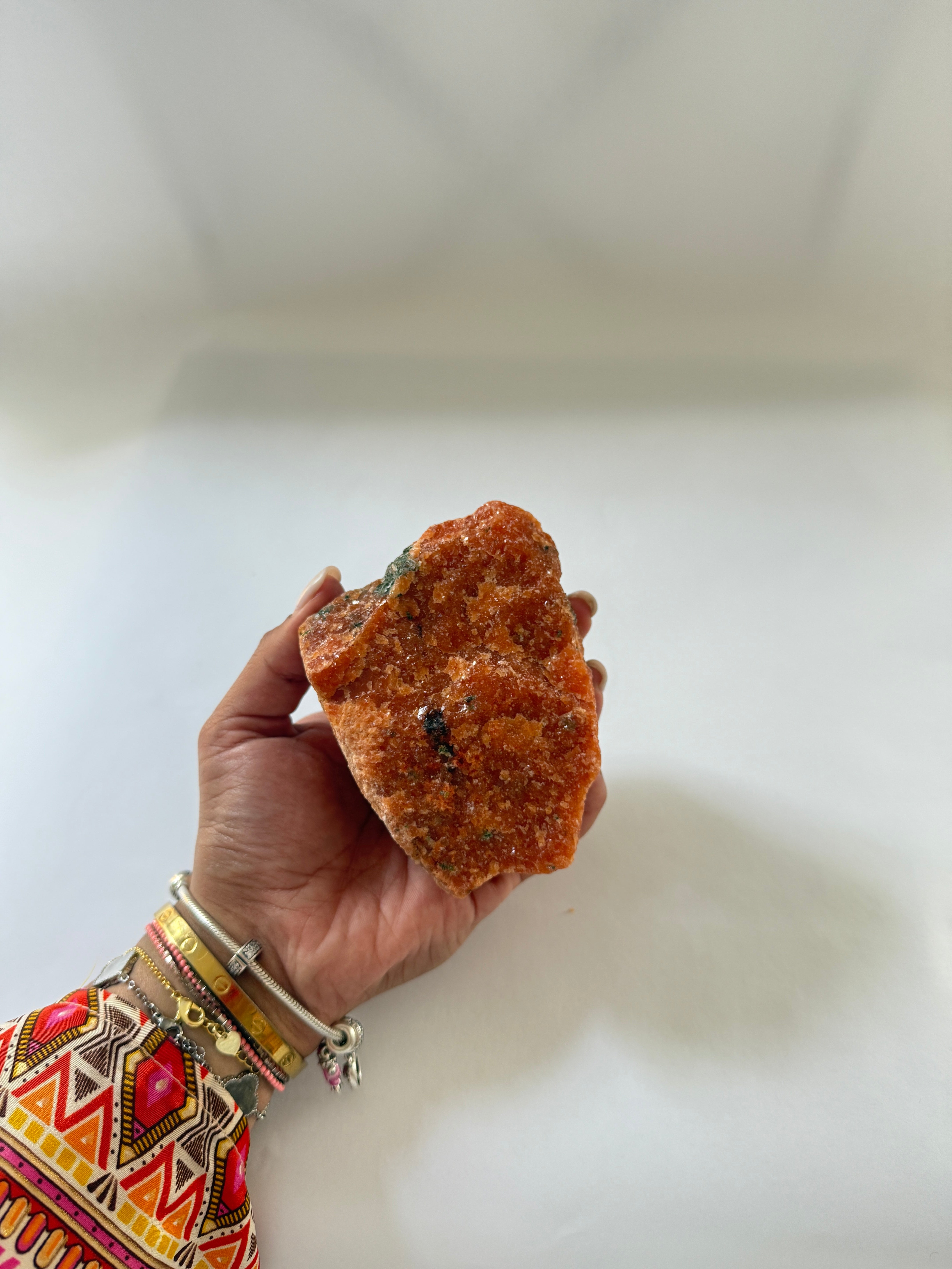 hand holding orange calcite specimen