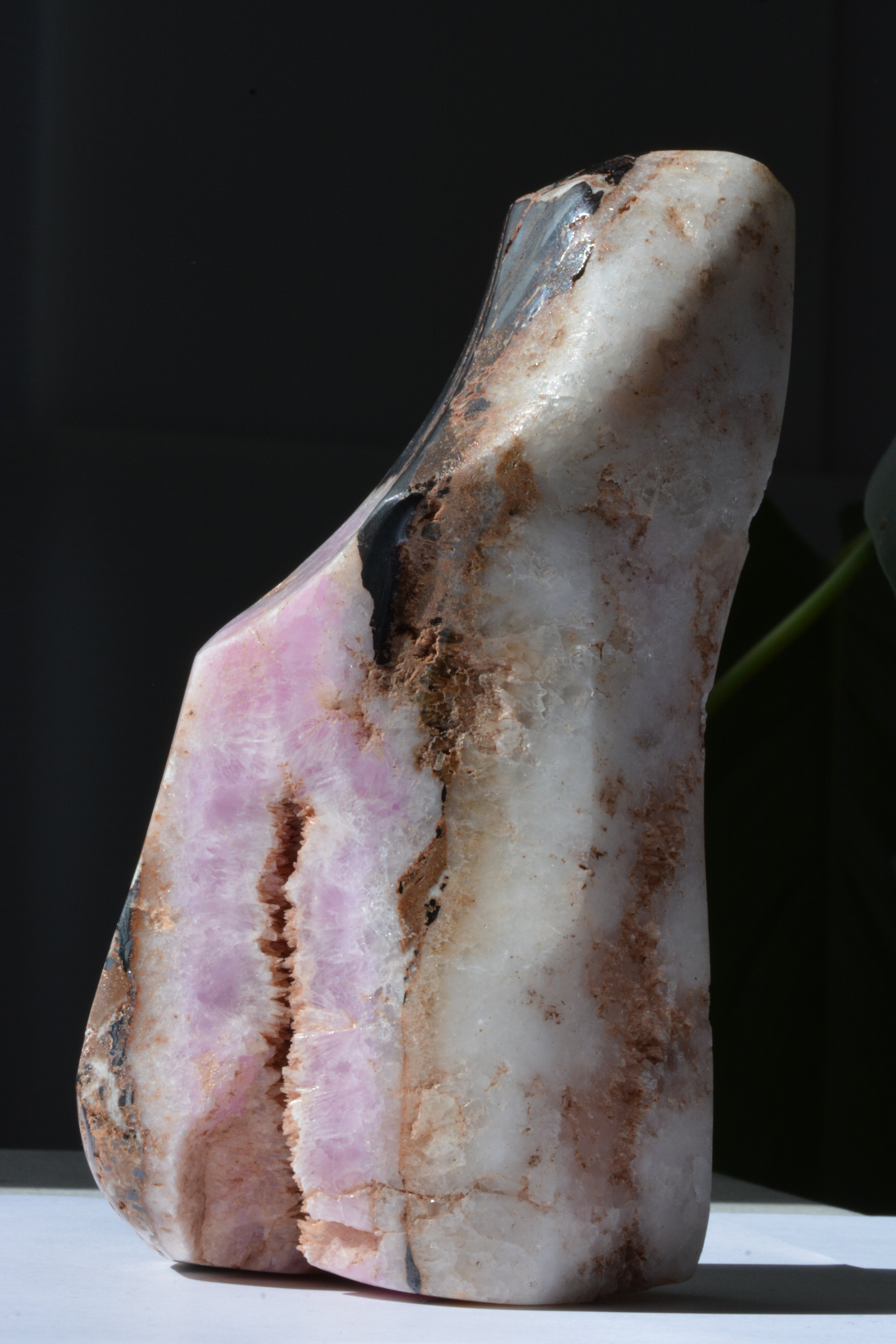 Side angle of pink Aragonite and Hematite crystal specimen showing natural formations and color variations