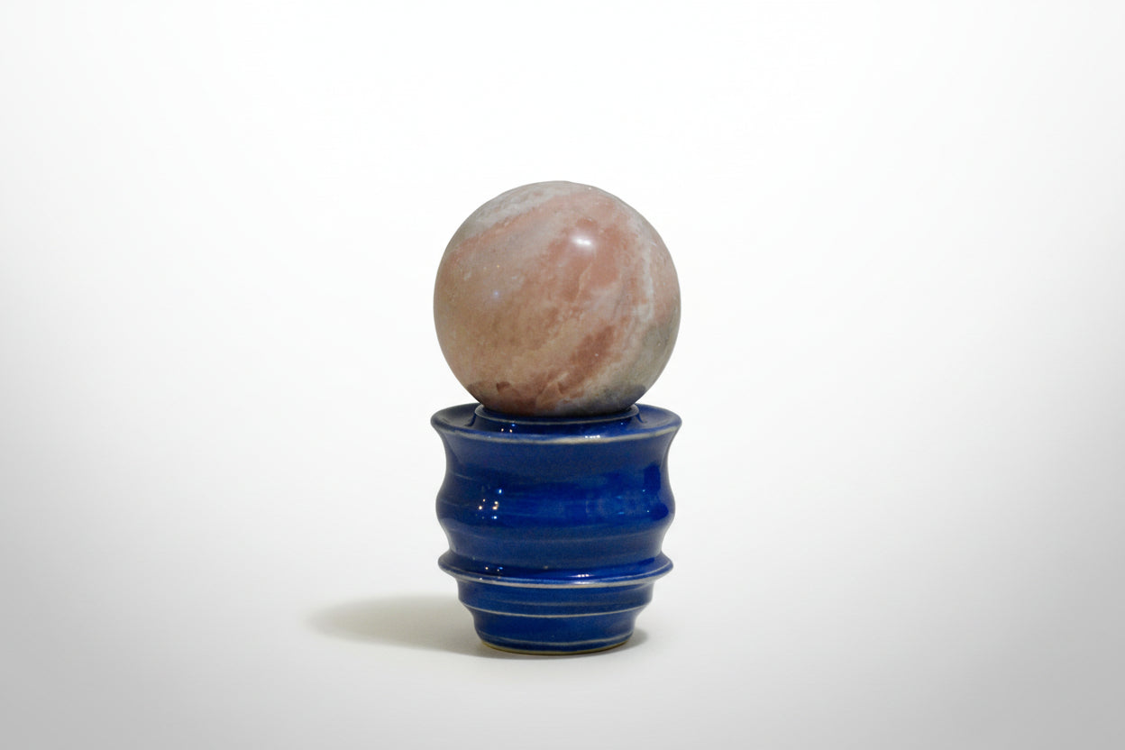 pink opal crystal ball on a ceramic sphere holder
