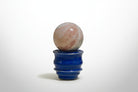 pink opal crystal ball on a ceramic sphere holder