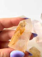 Hand holding a Golden Healer Dendritic Quartz tower to show size and detail — a powerful crystal for chakra alignment and energetic healing.