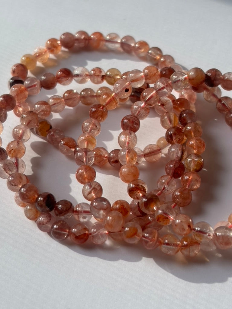 Close-up of crystal healing bracelets showing detailed gemstone fire quartz