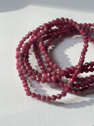 Close-up of crystal healing bracelets showing detailed gemstone faceted ruby
