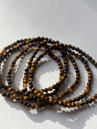 Close-up of crystal healing bracelets showing detailed gemstone textures like tigers eye 