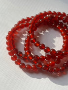  Colorful chakra crystal bracelet set arranged on altar cloth for spiritual healing and intention setting.