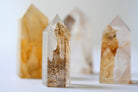Close-up of a Golden Healer Dendritic Quartz tower showing golden veins and delicate fern-like dendrites for spiritual clarity and grounding.