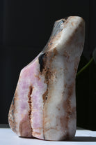 Side angle of pink Aragonite and Hematite crystal specimen showing natural formations and color variations