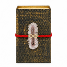 Decorative book to hold a tarot deck,  with a red string, amethyst crystal, and gold infinity symbol on a white background