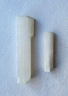 Natural Selenite crystal wand on linen cloth – used for energy cleansing, aura clearing, and spiritual rituals