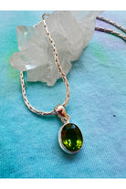 Green peridot crystal necklace promoting heart chakra balance